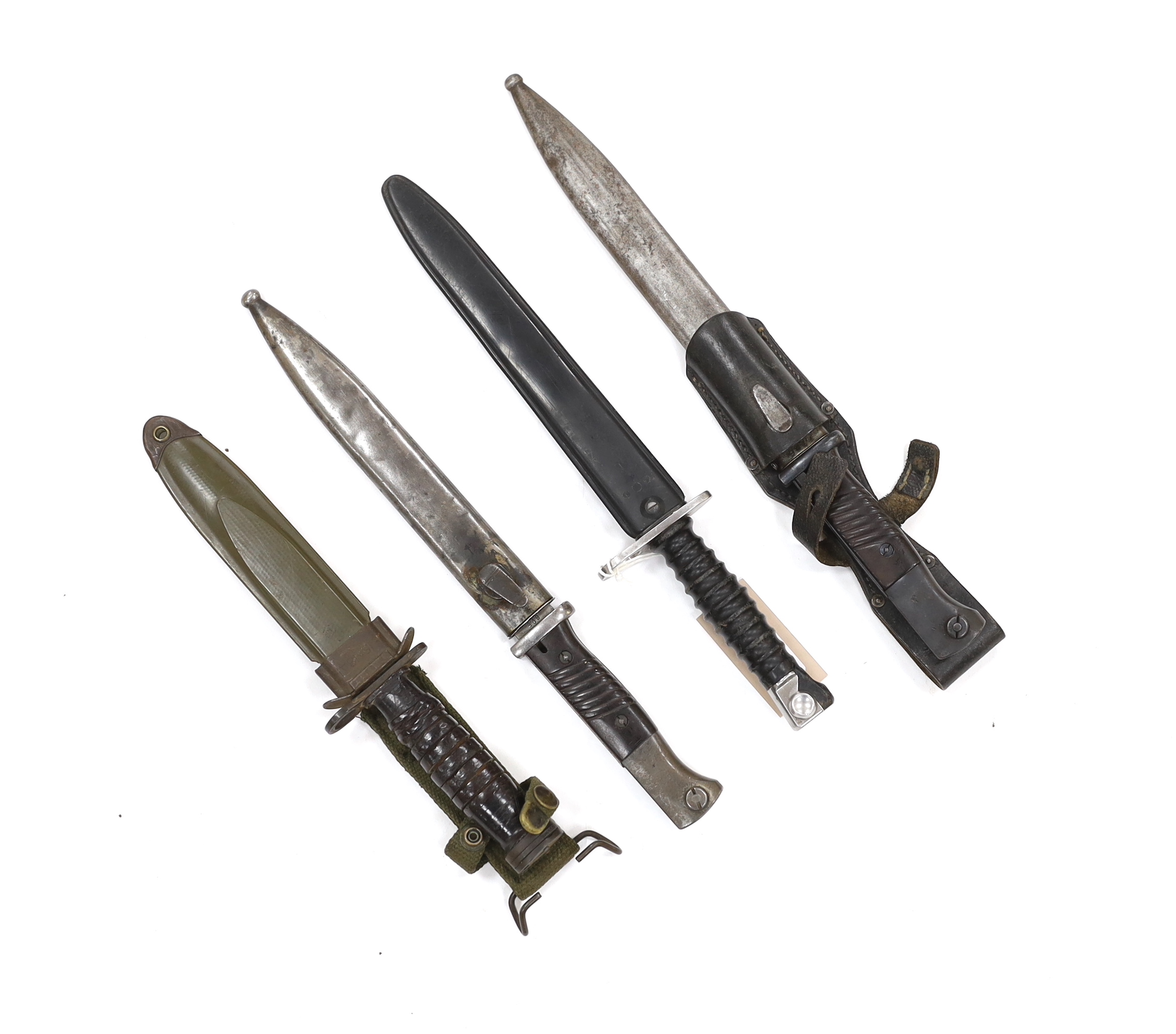 Four bayonets; two Mauser bayonets in scabbards, an American M8A1 carbine bayonet in a scabbard, and another